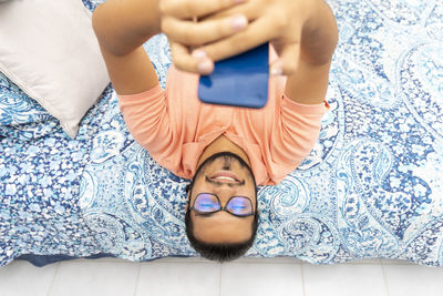 High angle view of man lying down on bed