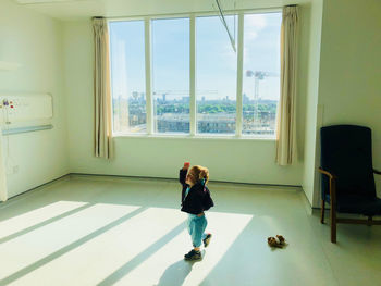 Woman standing by window at home