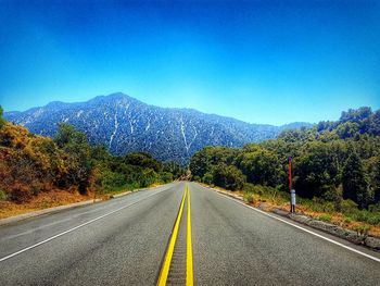 Empty road with trees in background