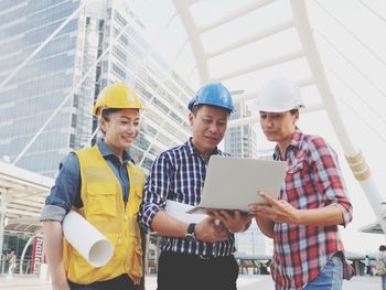 Architects discussing over laptop while working at construction site