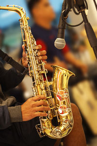 Midsection of man playing saxophone during performance