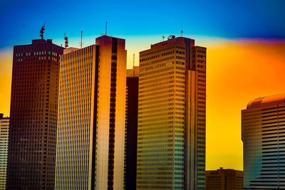 Low angle view of skyscrapers against sky during sunset