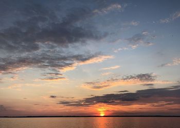 Scenic view of sea against dramatic sky during sunset