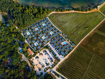 High angle view of agricultural field by buildings in city