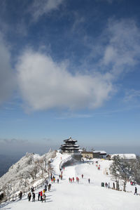 People walking on snow covered landscape during winter