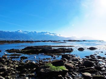 Scenic shot of calm sea with mountain range in background