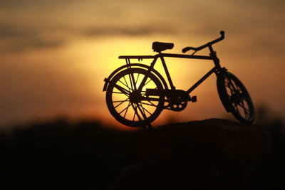 Close-up of silhouette bicycle against sky during sunset