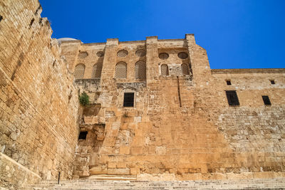 Low angle view of old building against blue sky