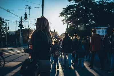 People walking in city against clear sky