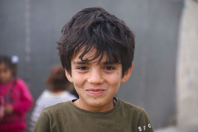 Cute syrian child in a refugee camp in the rain.