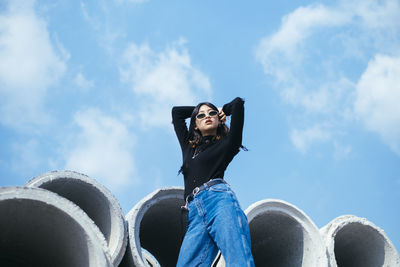 Low angle view of woman sitting against sky