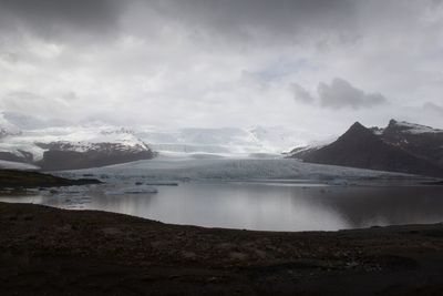 Scenic view of lake and snowcapped mountains against sky