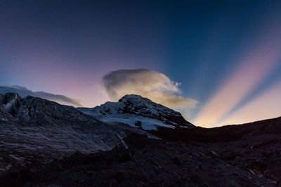 Scenic view of snowcapped mountains against sky during sunset