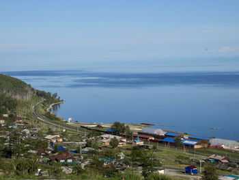 High angle view of houses by sea against sky