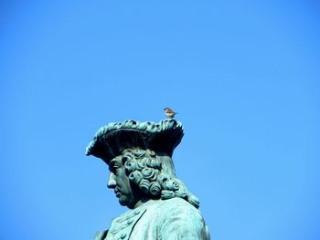 Low angle view of statue against clear blue sky