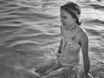 High angle view of girl sitting in sea