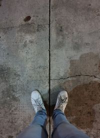 Low section of person standing on footpath at night