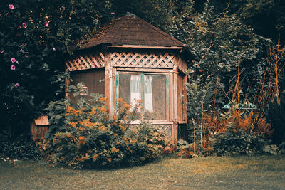 House and trees on field against building