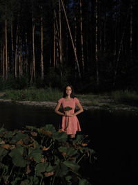 Rear view of woman standing in forest