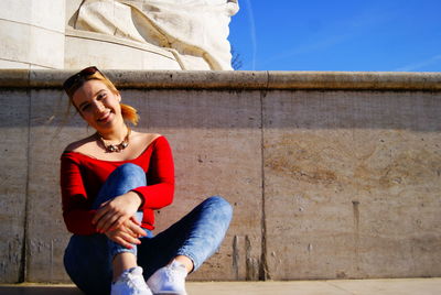 Portrait of confident young woman sitting on steps in city