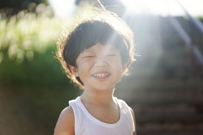 Sunlight falling on smiling boy standing at park