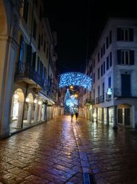 Man walking on illuminated street at night