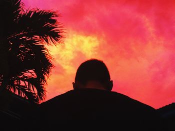 Low angle view of silhouette man against orange sky