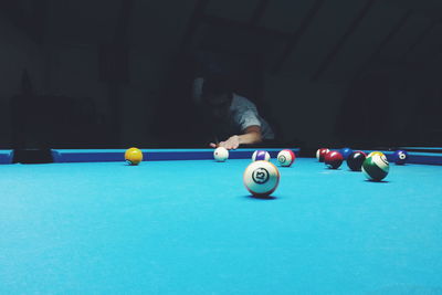 Young man playing pool on table