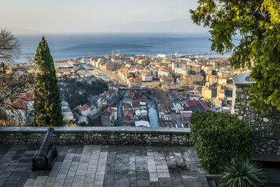 High angle view of town by sea against sky