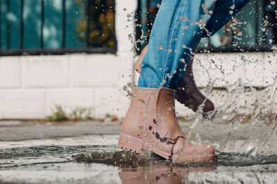 Low section of woman with wet umbrella in rainy season