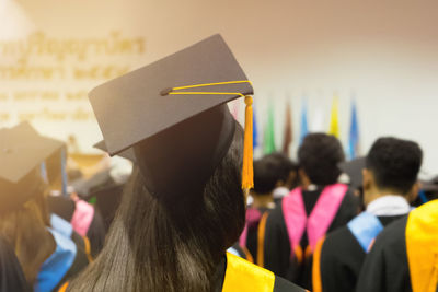 Rear view of woman in graduation during ceremony