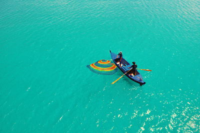 High angle view of people rowing boat in sea