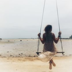 Rear view of young man fishing on beach