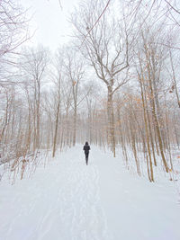 Woman walking on snow covered land