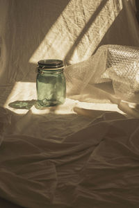 High angle view of glass jar on textile