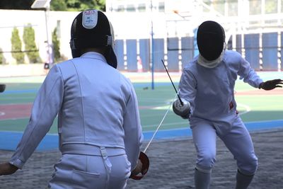 Rear view of man get ready for fencing sports.  