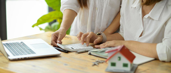 Low section of woman holding hands on table