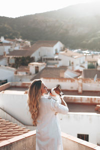 Rear view of woman standing against buildings in town