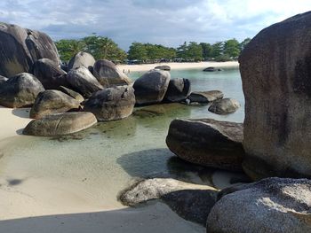 Rocks on beach against sky