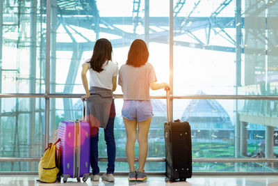 Rear view of women standing at airport