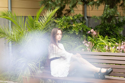 Portrait of young woman sitting on bench