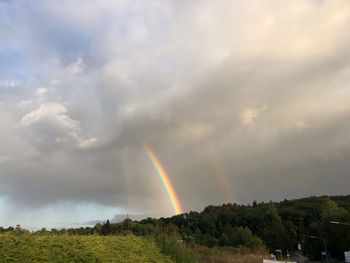 Scenic view of rainbow over landscape against sky