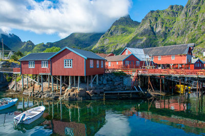 House by lake against sky