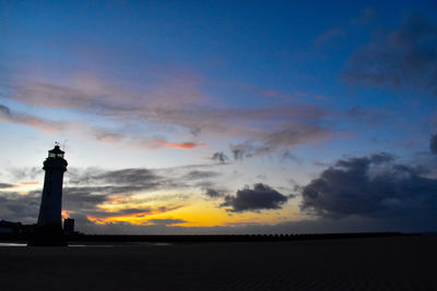 Silhouette lighthouse against sky during sunset