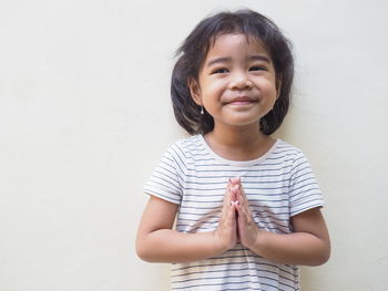 Close-up of cute girl standing against wall