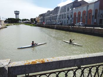 People on river against city