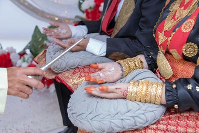 Midsection of couple performing wedding rituals