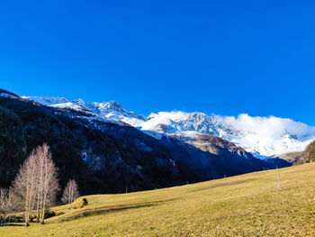 Scenic view of snowcapped mountains against blue sky