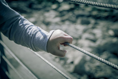 Close-up of hand holding rope