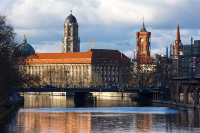 Bridge over river in city against sky